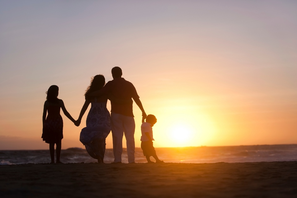 Familia de cuatro en una playa al atardecer 