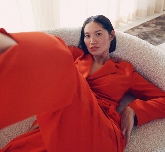 Woman in a red jumpsuit sitting on a chair