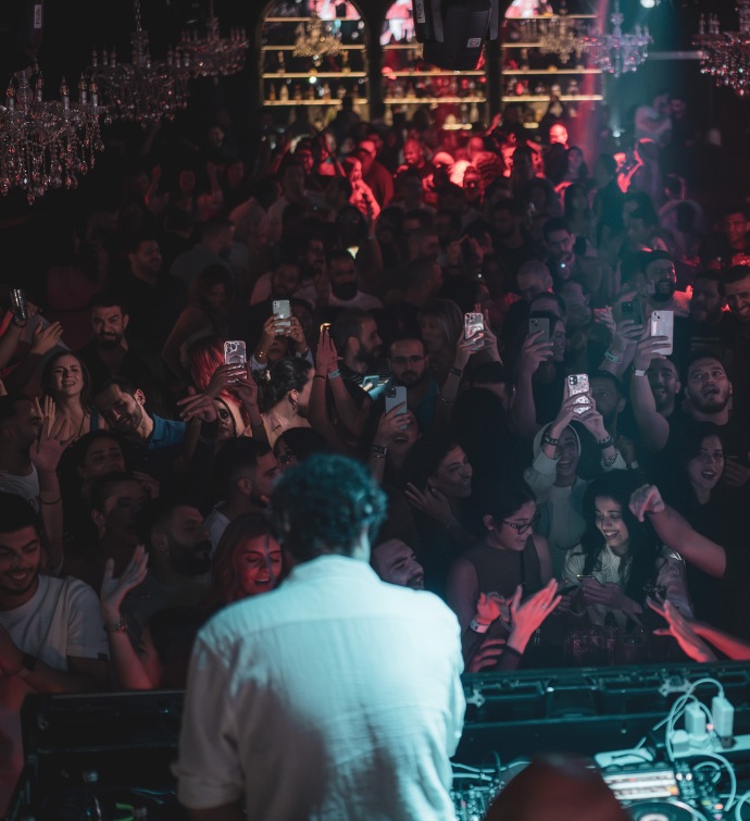 DJ at DJ booth in front of a crowd of people at Black Orchid nightclub