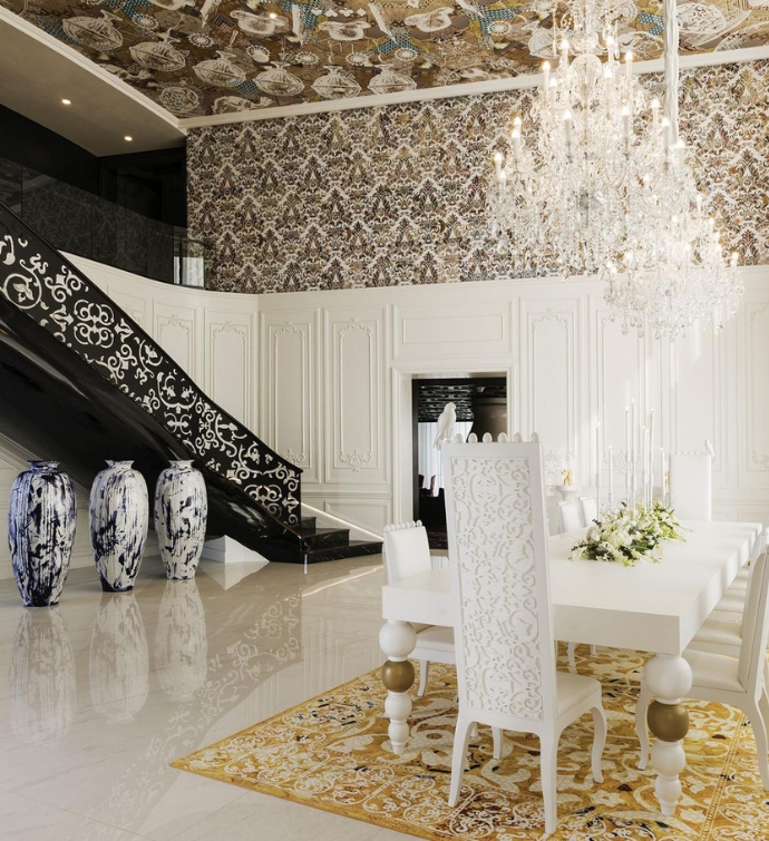 Salle à manger décorée avec une longue table blanche et des chaises hautes, et un escalier