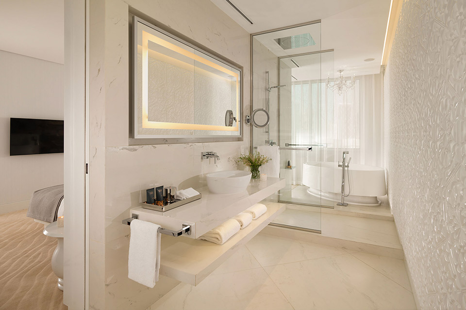 Salle de bain avec un grand miroir et un lavabo.