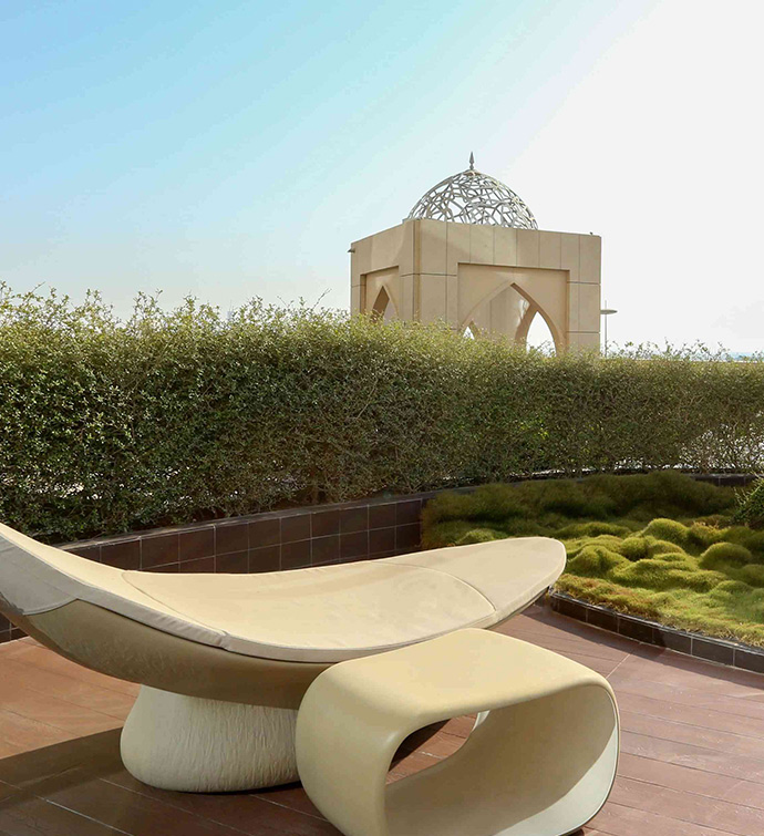 White chair on patio overlooking lush green lawn.