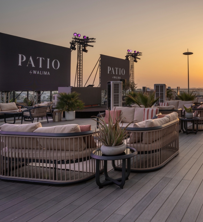 Patio at Walima Doha with large screens and couches 