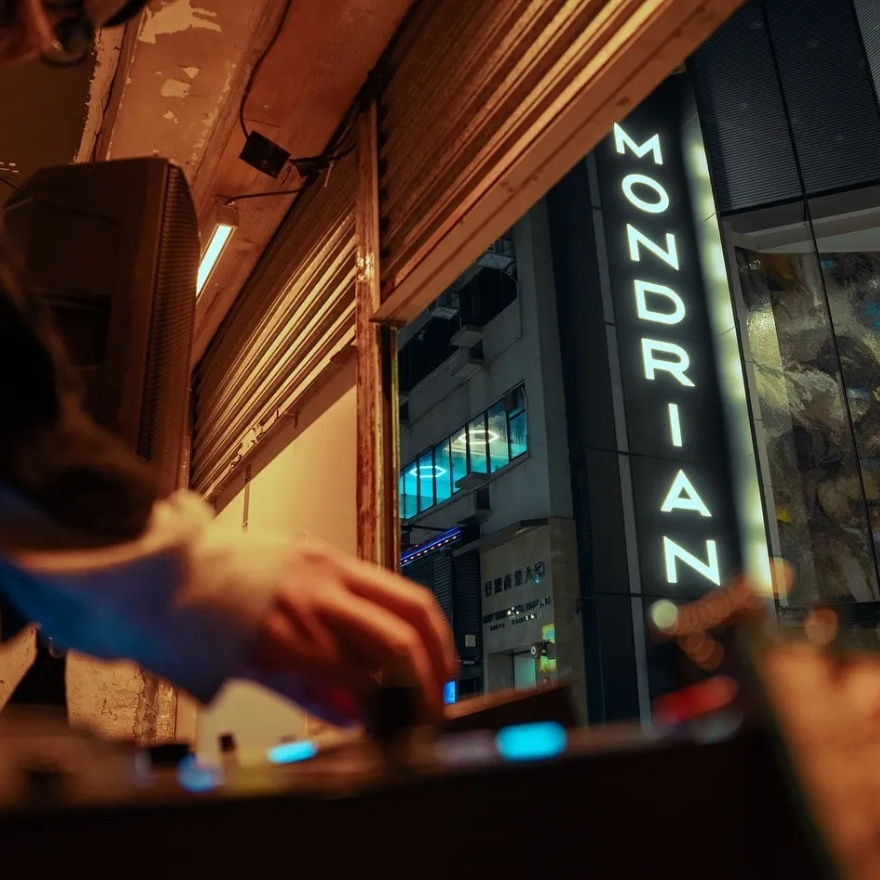 DJ set with mondrian sign in background