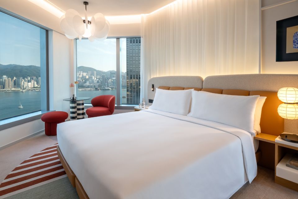 Hotel room featuring a large bed, yellow headboard, table and views of the harbour