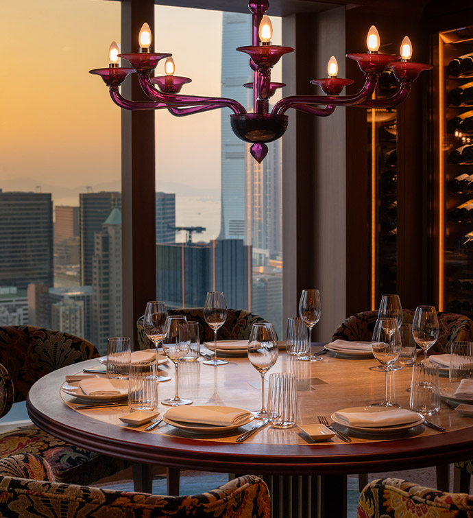 Circular table surrounded by chairs in a dining room.