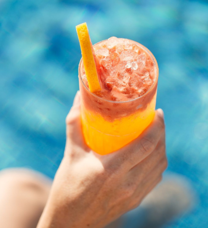 a bright yellow cocktail with an azure blue background