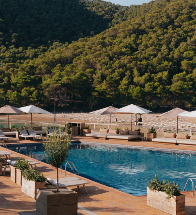 a splash in a crystal blue pool surrounded by lush green hills