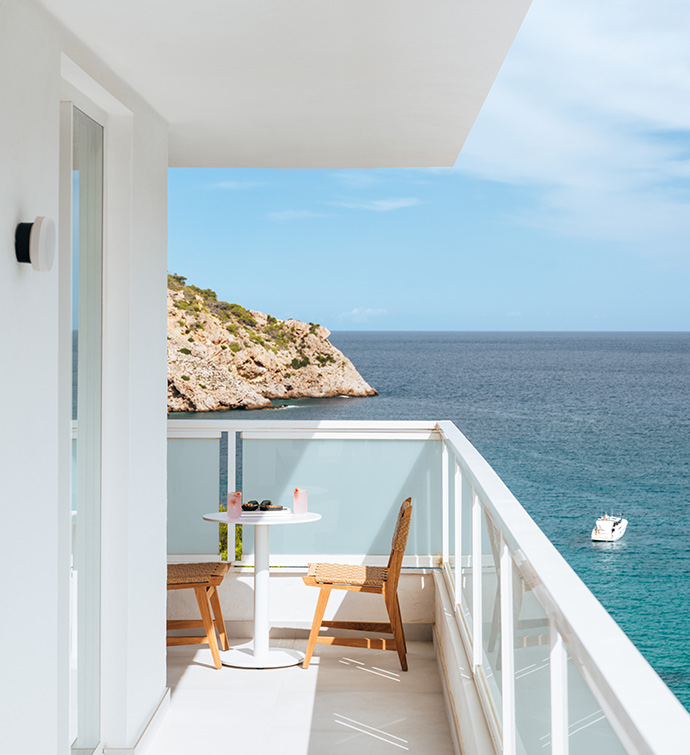 Una serena vista al mar desde un balcón con una mesa y sillas.