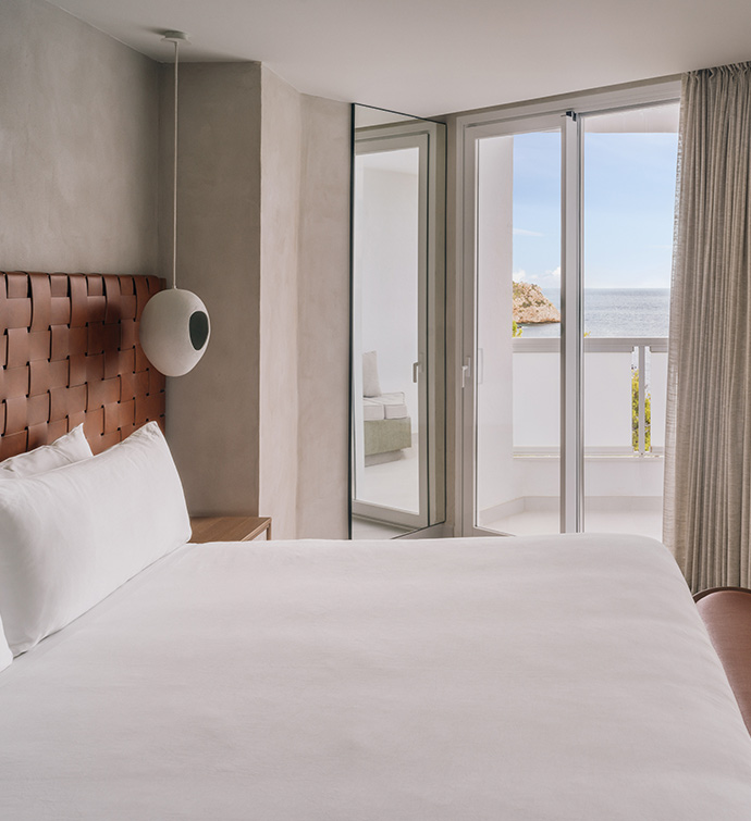 Un amplio dormitorio con una cama con vistas al océano.