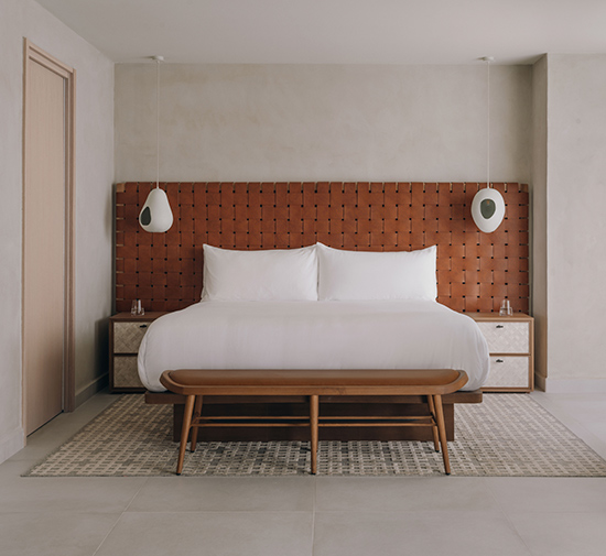 A neatly made bed with crisp white sheets and plump pillows.