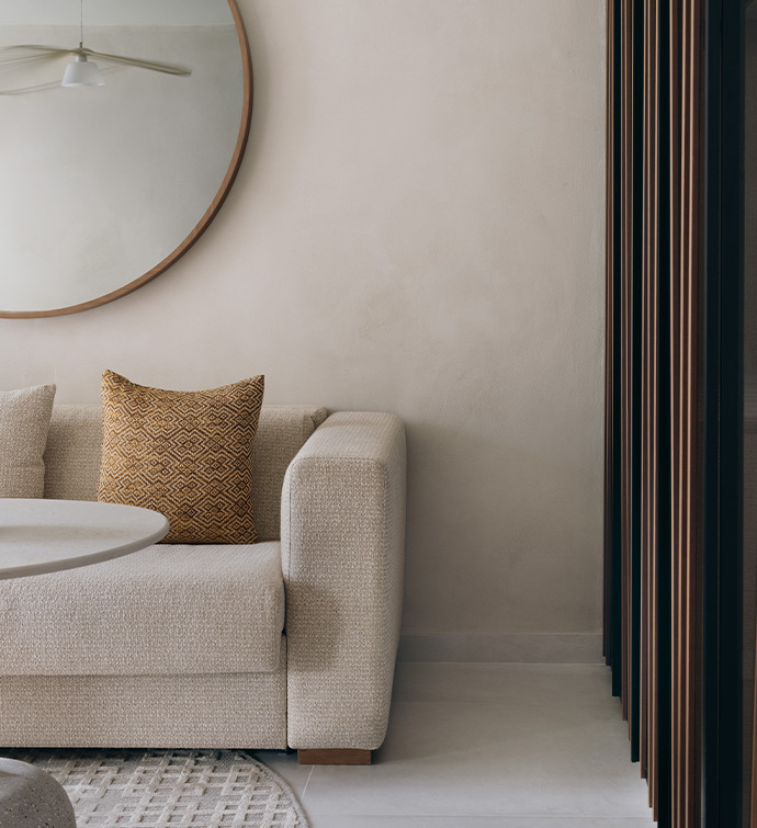 A cozy living room with a comfortable couch, a stylish coffee table, and a decorative mirror.