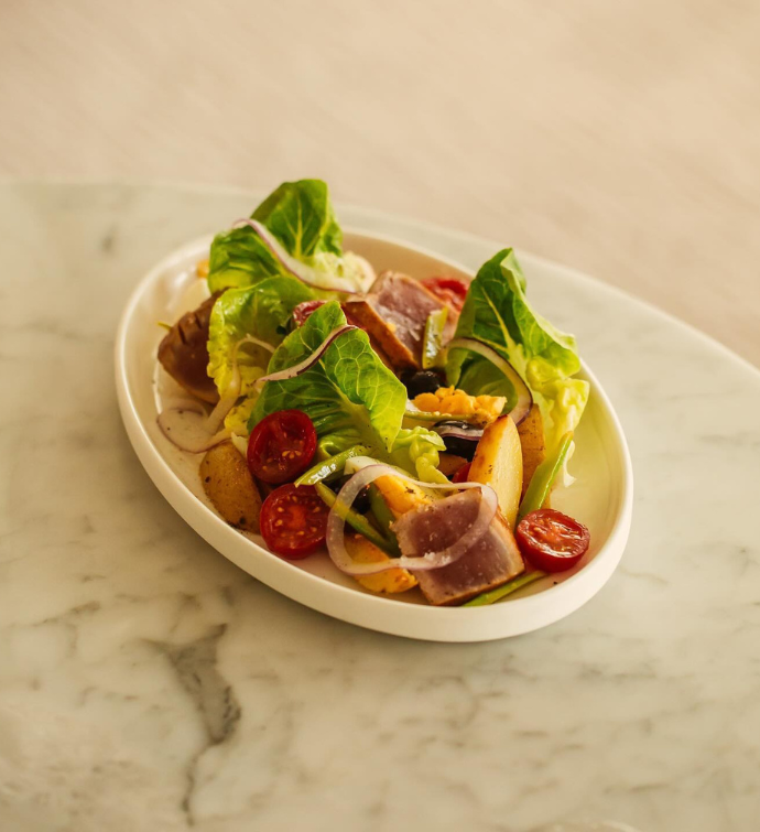 a bowl with large lettuce pieces plated on a table