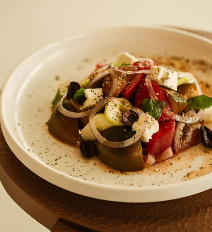 un plato mediterráneo con champiñones, cebollas y queso feta presentado de forma bonita