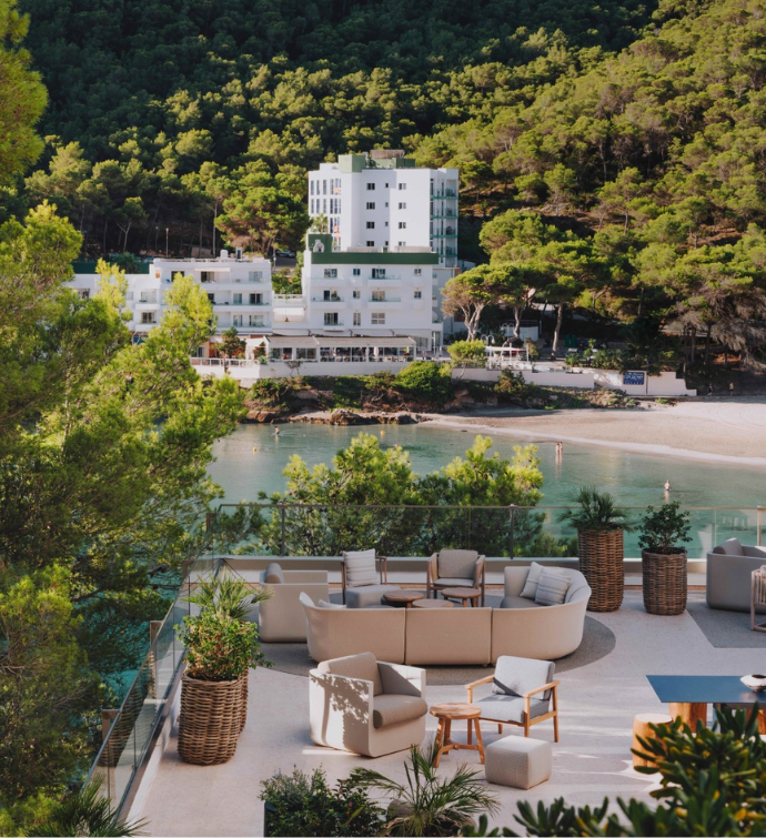 una bonita terraza con muebles de comedor con vistas a la bahía de Calla Llonga