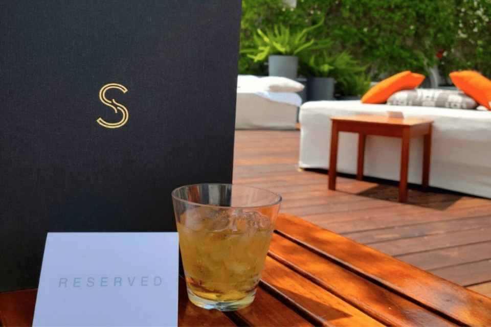 Skybar menu next to a cocktail and Reserved sign