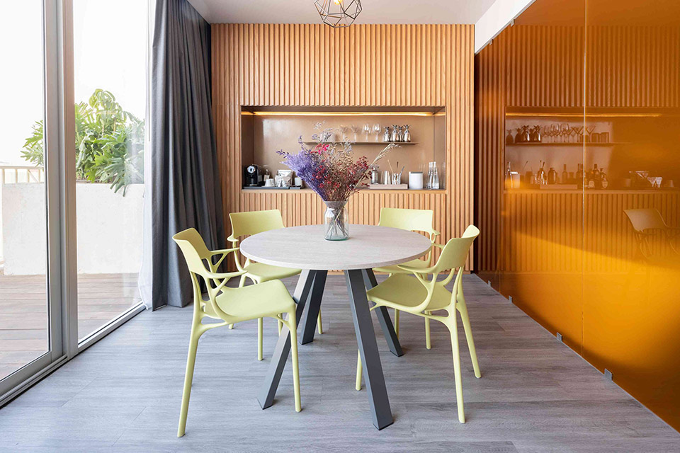 A contemporary dining room with vibrant orange walls and elegant wooden floors.