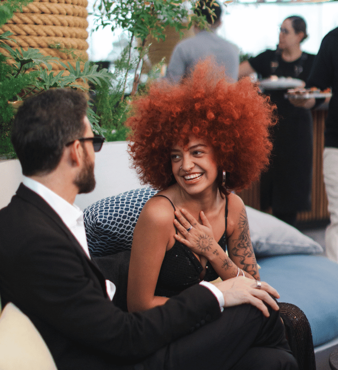 a couple enjoying themselves sitting on a rooftop terrace at a table 