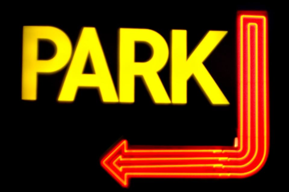 Yellow park sign with an orange arrow