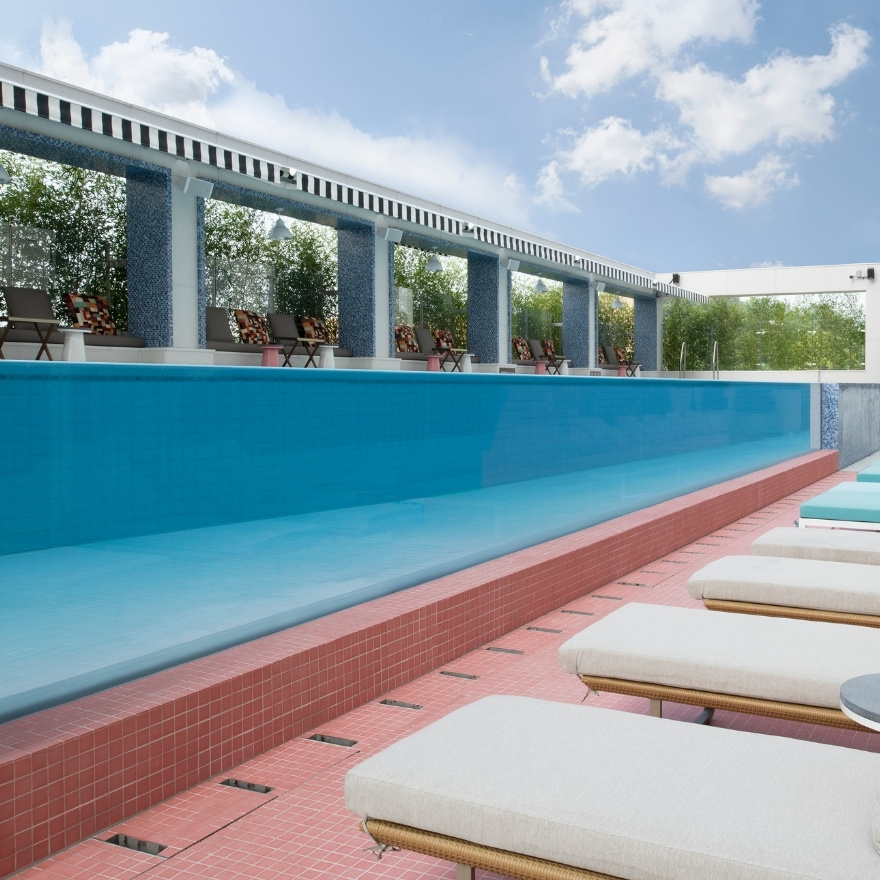 Blue infinity pool with chaise lounges on the side