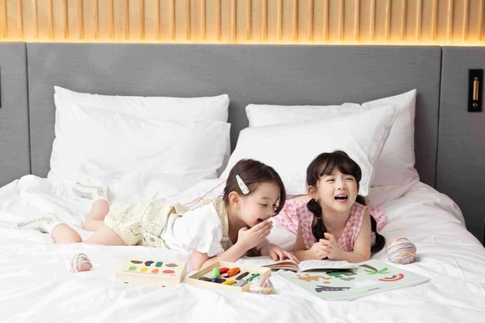 Two kids on a bed doing activities