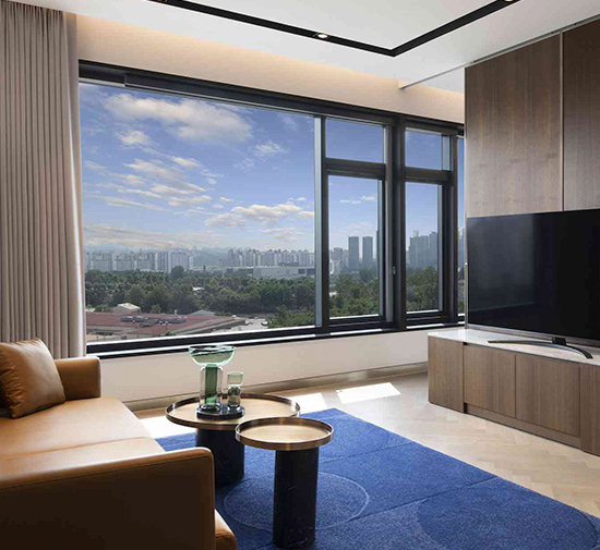 A contemporary hotel room with a spacious window offering a panoramic view of the cityscape.