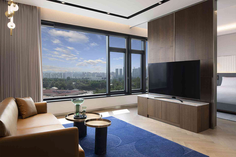 A contemporary hotel room with a spacious window offering a panoramic view of the cityscape.