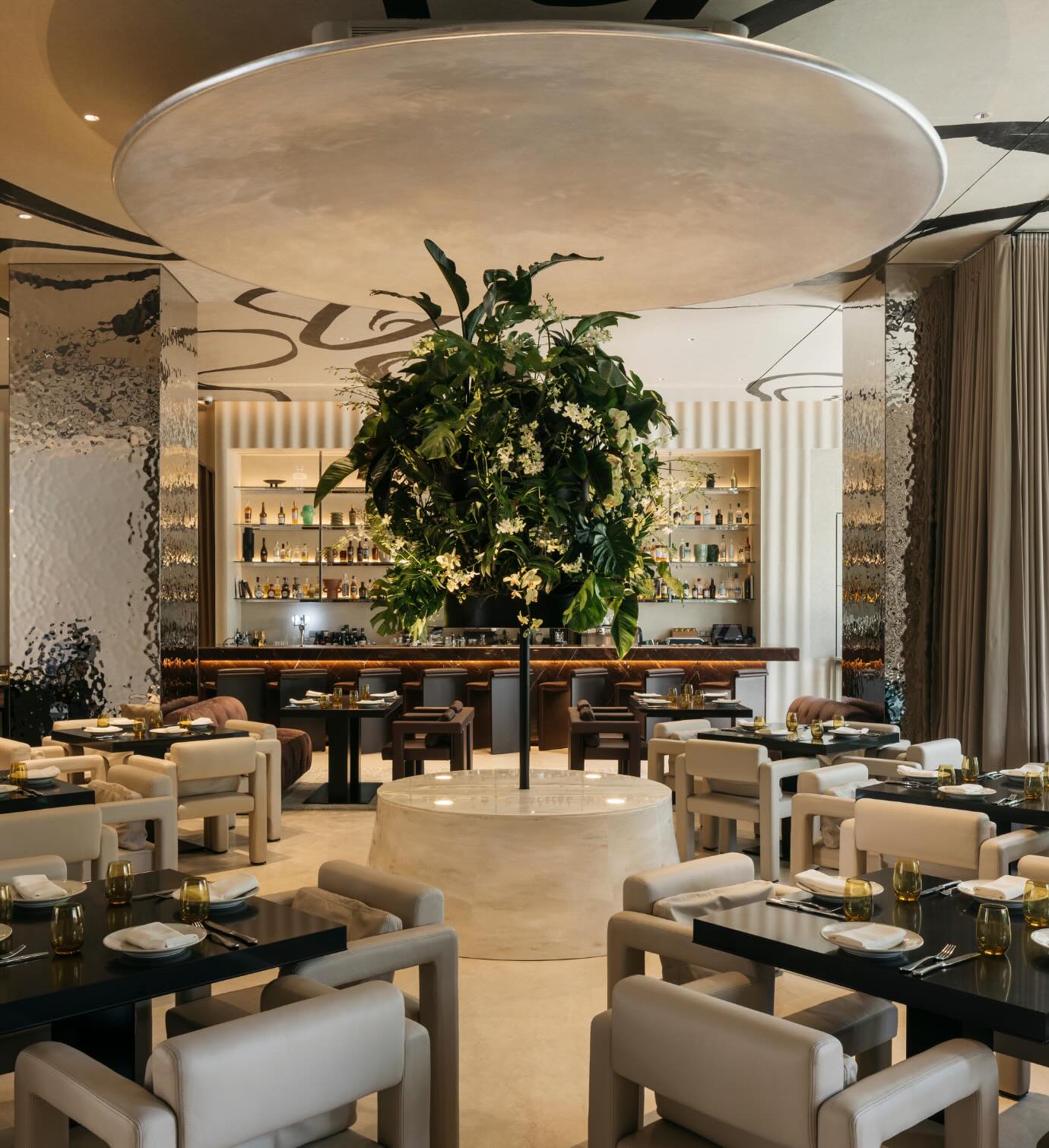 Interior of bottega di carna singapore restaurant with a large tree in the middle of the room