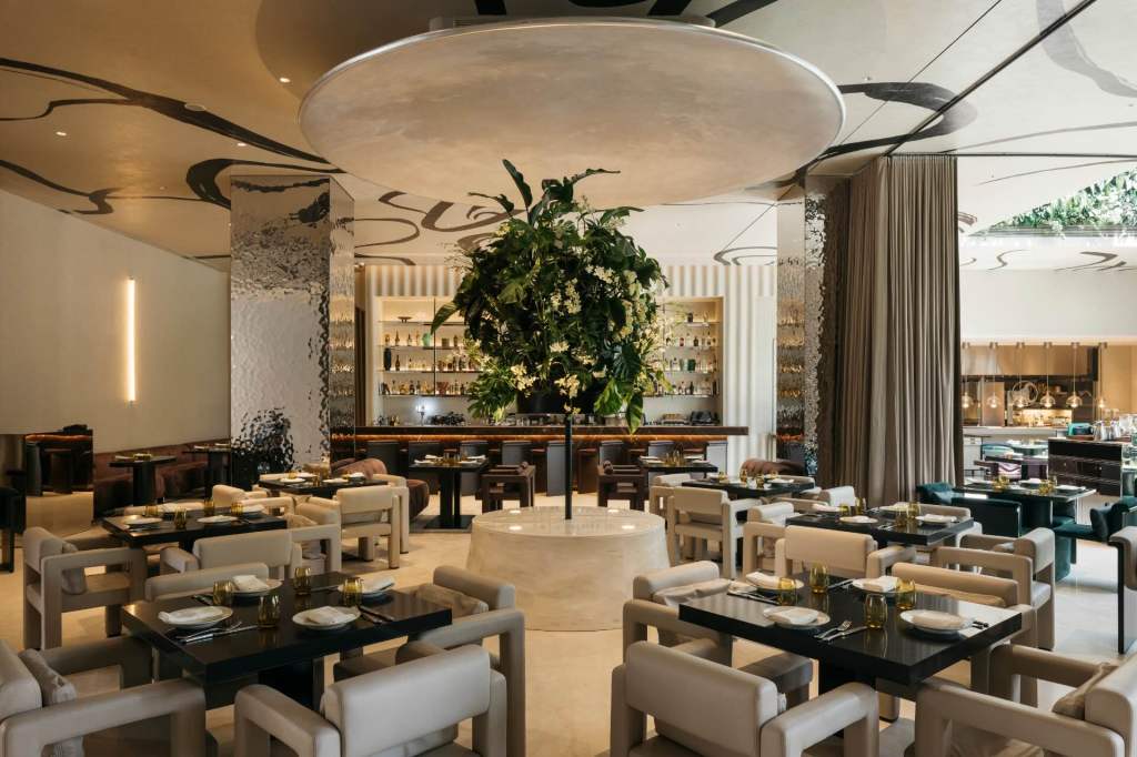 Interior of bottega di carna singapore restaurant with a large tree in the middle of the room