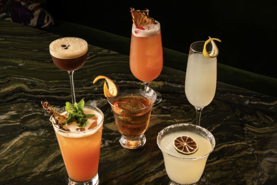 Six various color and size cocktails on a marbled bar top