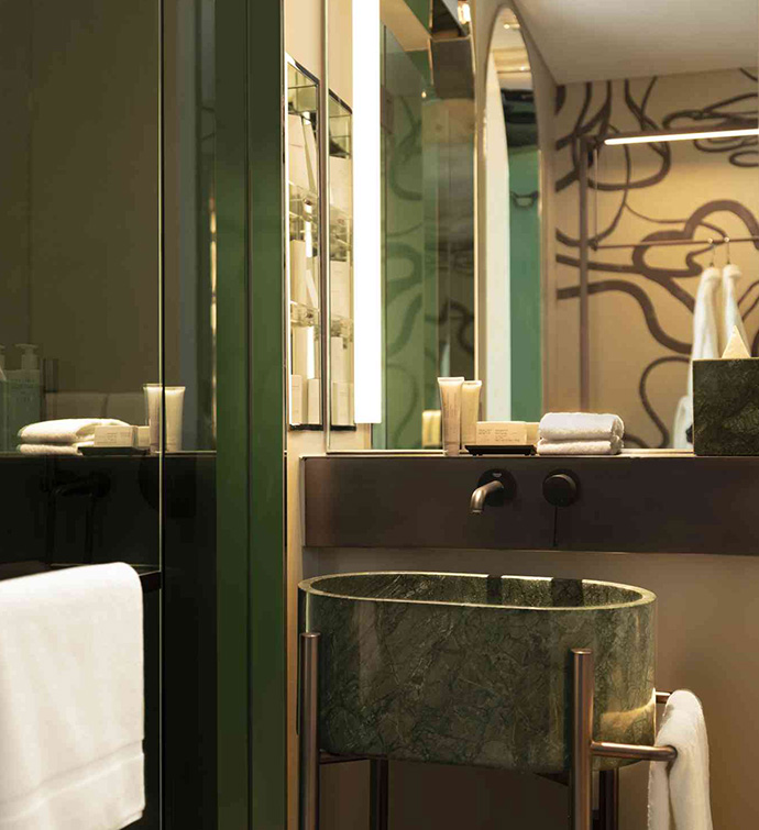 A bathroom with a sink, mirror, and shower with glass door.