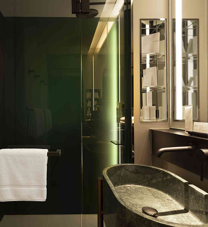 A bathroom with a sink, mirror, and shower with glass door.