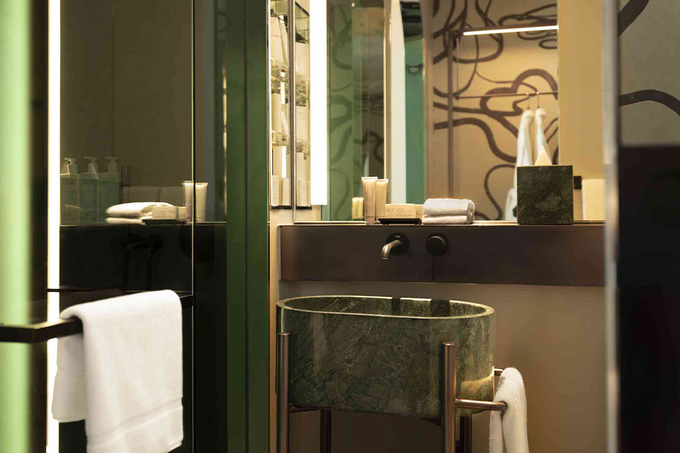 A bathroom with a sink, mirror, and towel rack.