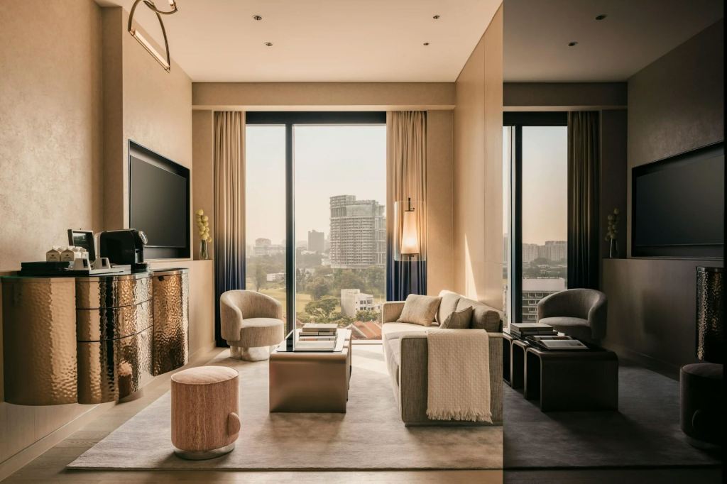 Modern living room area with TV, couch and floor to ceiling windows