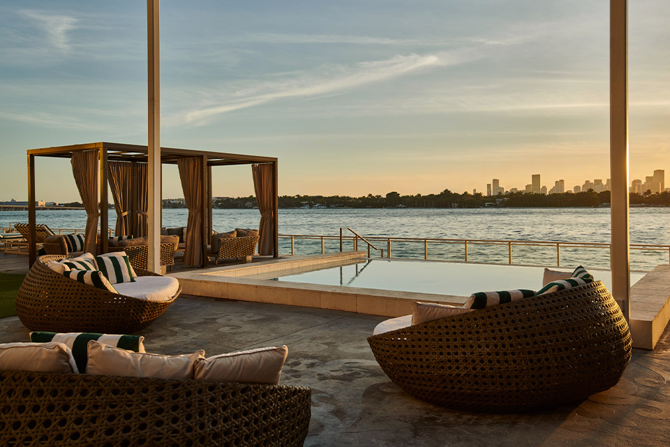 Piscina infinita, cabañas y asientos con vistas al agua