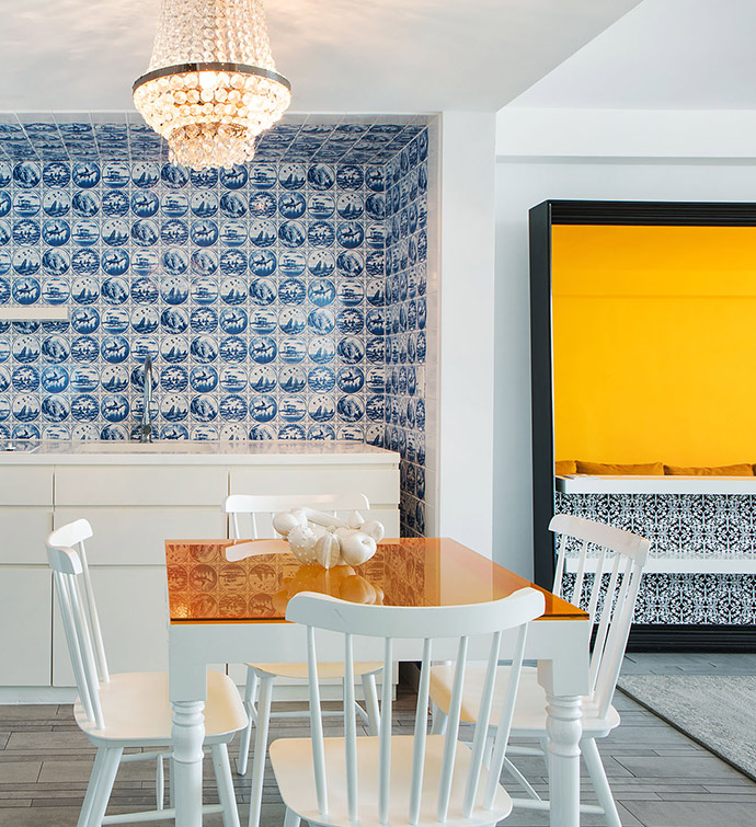 A kitchen with a wooden table and four chairs arranged neatly in the center.