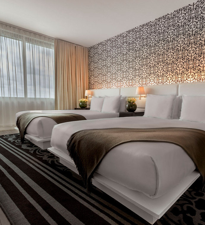 A spacious hotel room featuring a king-sized bed and a comfortable sofa for relaxation.