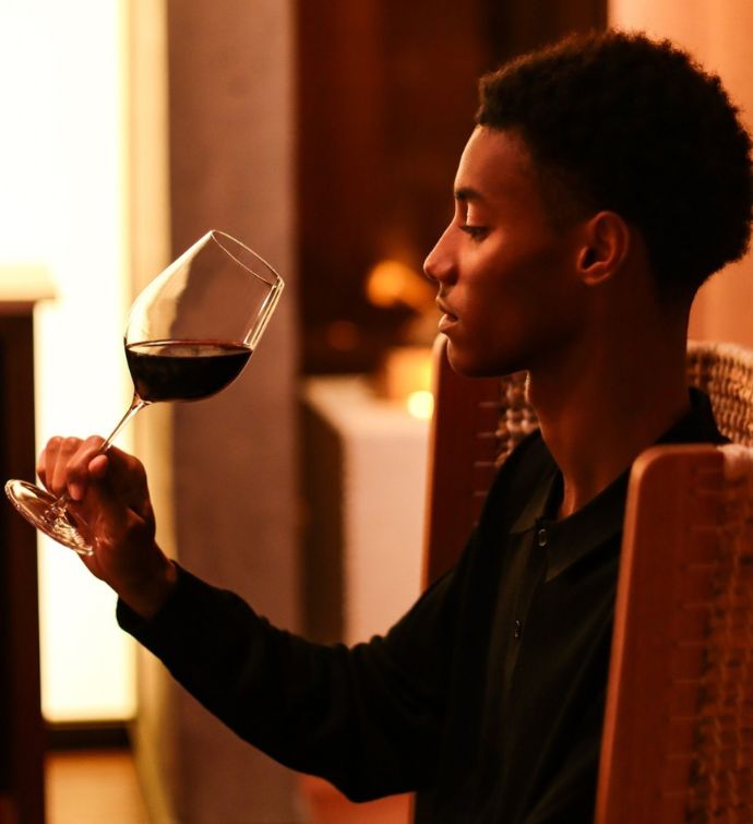 Hombre tomando una copa de vino tinto en Morimoto Bordeaux