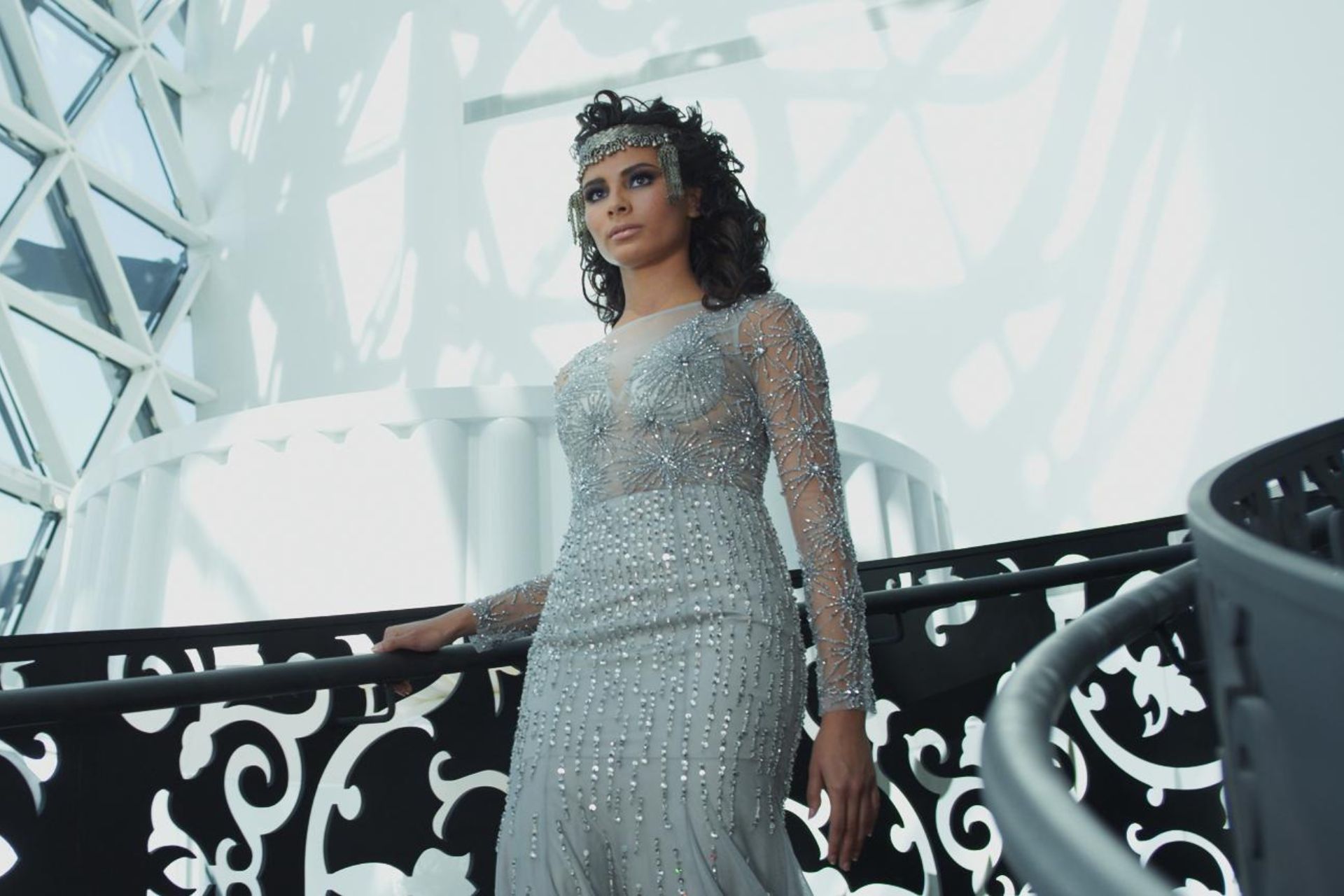 An elegantly dressed woman walking down a staircase 