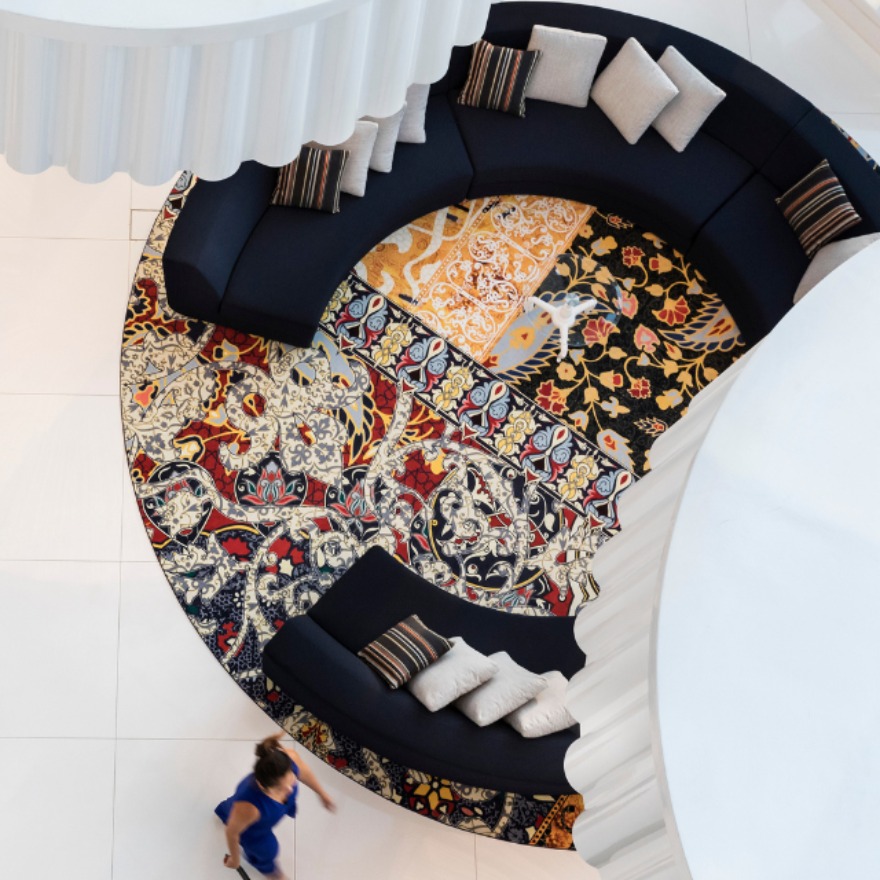 vue d'ensemble d'un hall avec des tapis circulaires, des fauteuils et des dalles blanches