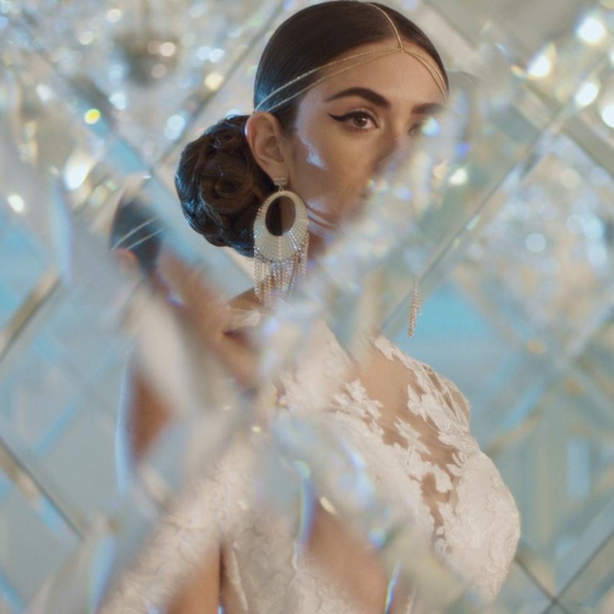 Foto de una mujer vestida de novia mirando al frente con cristales y luces a su alrededor