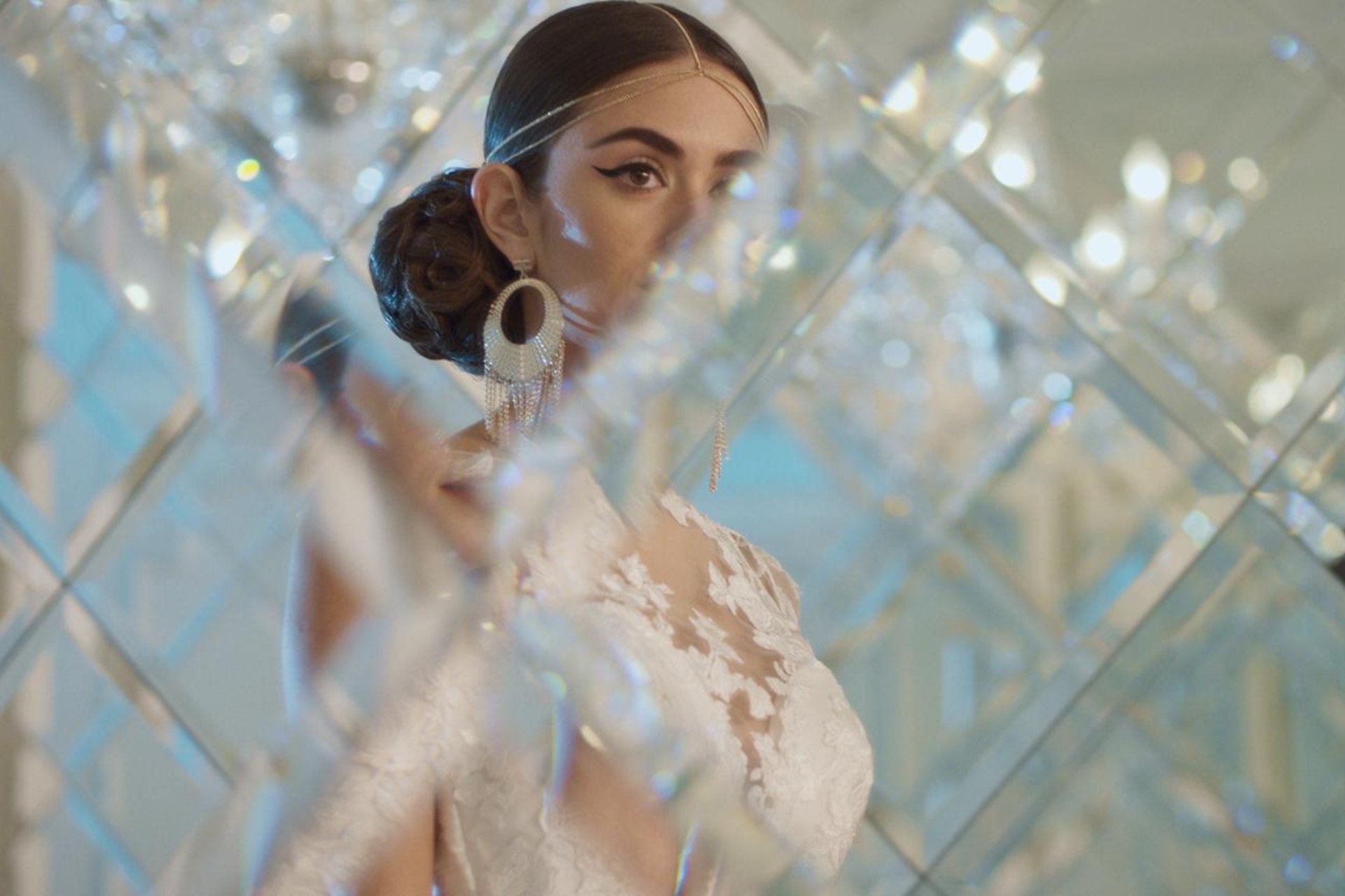 Foto de una mujer vestida de novia mirando al frente con cristales y luces a su alrededor