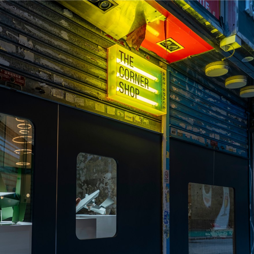 Image of the exterior of The Corner Shop at Mondrian Hong Kong - an illuminated yellow sign in an alleyway