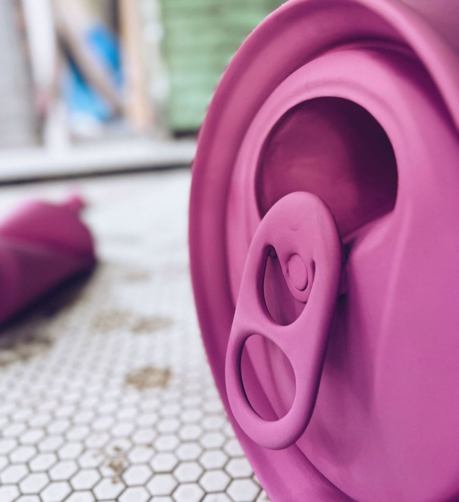 Two oversized pink cans, part of the Crushed Cans installation by Caroline Tronel