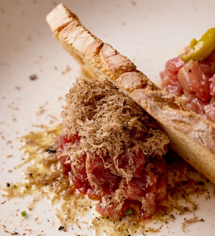 Close up image of tuna tartare with slice of bread in the middle