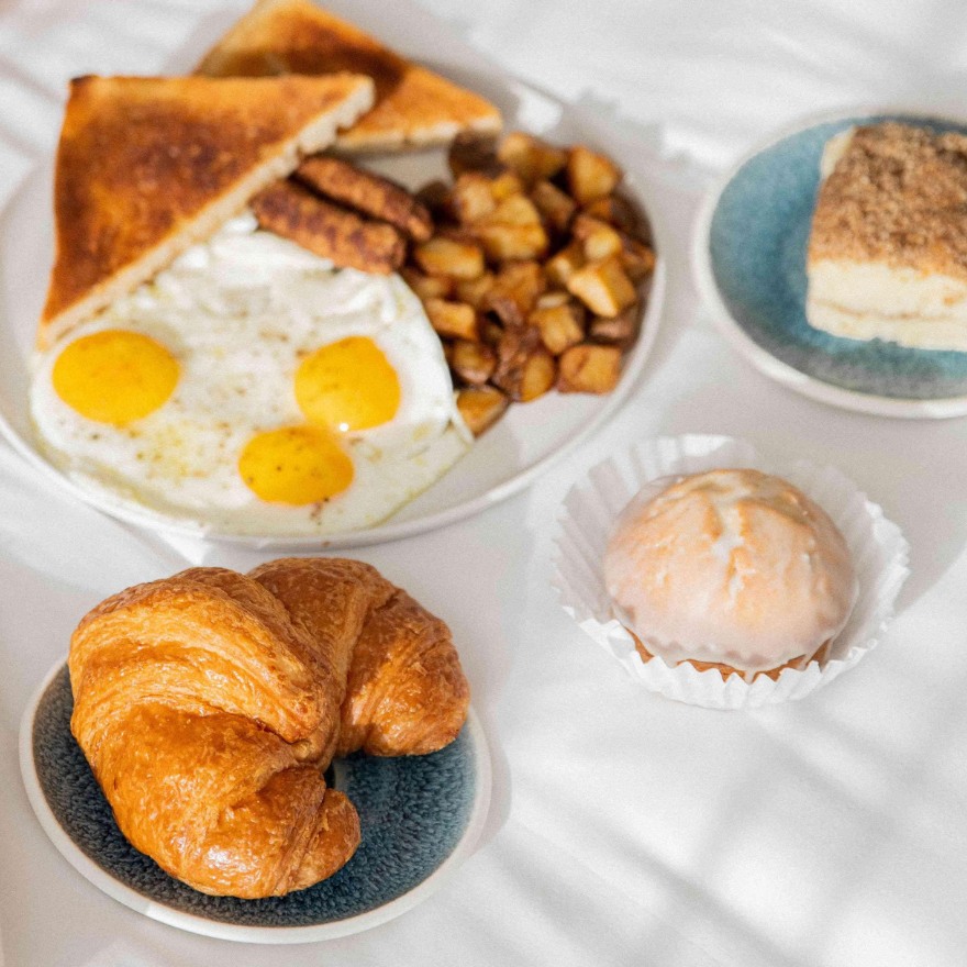 Breakfast including eggs, potatoes, a croissant and scone