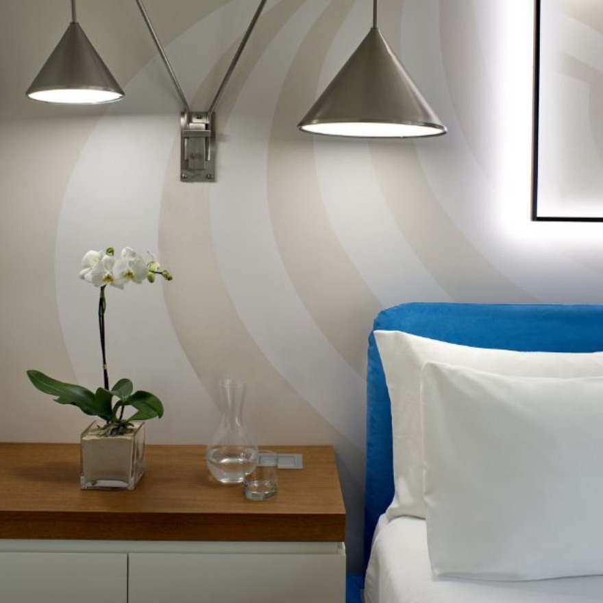 Mondrian Los Angeles guestroom with a blue headboard and wall lighting