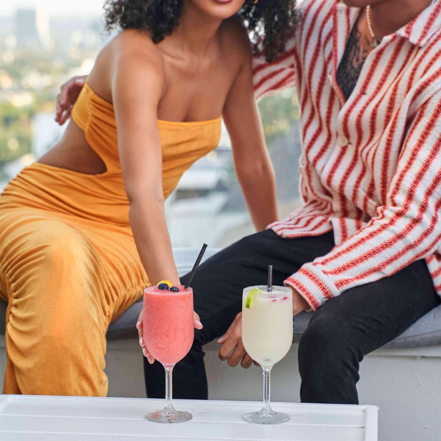 Man and woman embracing and enjoying cold cocktails