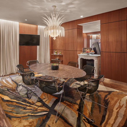 an executive boardroom with a beautiful chandelier and cherry wood walls