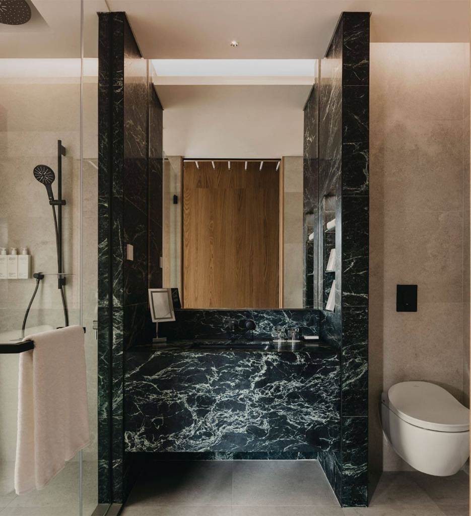 A modern bathroom with a sleek marble sink and a toilet.